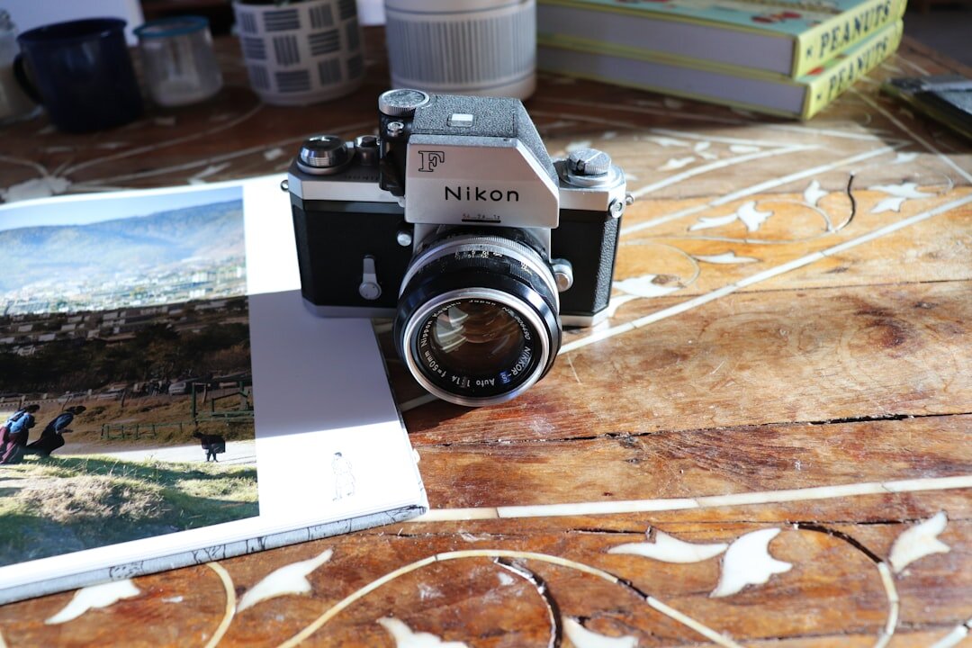 Vintage camera and printed photographs on a wooden desk